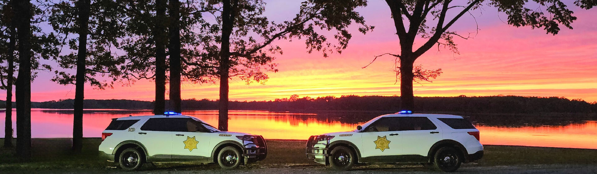 2 Sheriff's Office Vehicle with bright sunset in background